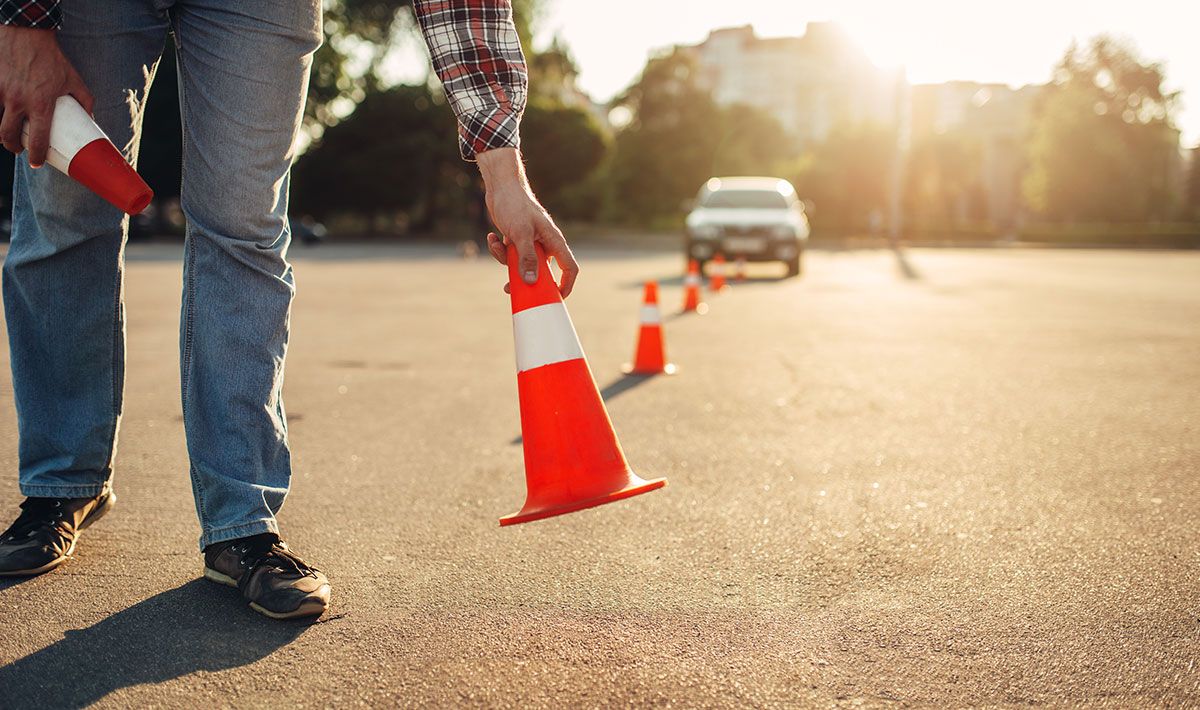 Fahrlehrer stellt Warnkegel auf