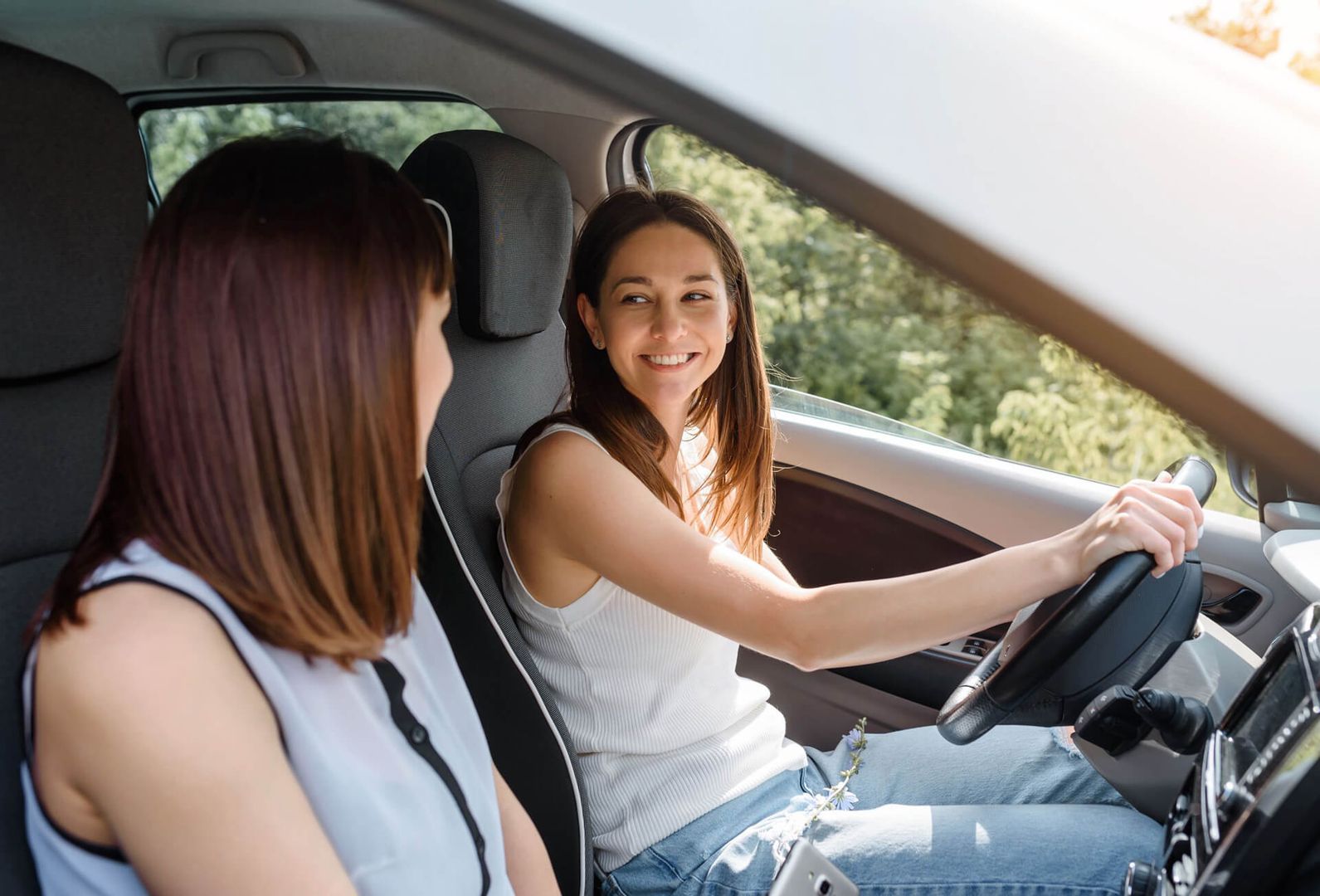 Eine Fahrerin mit Begleitperson im Auto